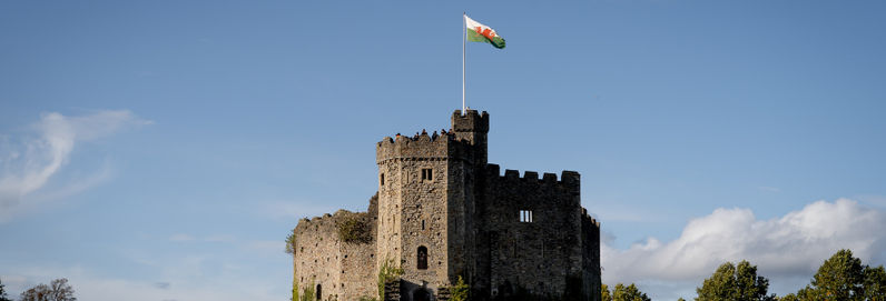 a castle with a clock tower with Cardiff Castle in the background