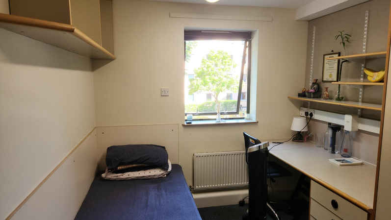 a bedroom with a bed and desk in a small room