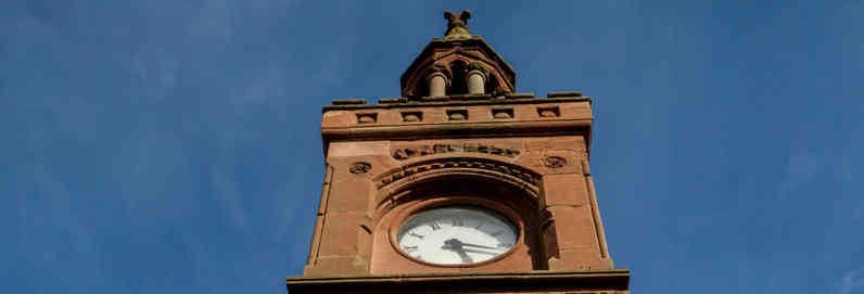 a large tall tower with a clock on the side of a building