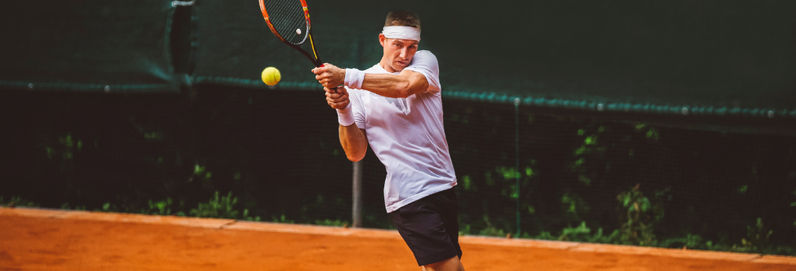 a man swinging a racket at a ball