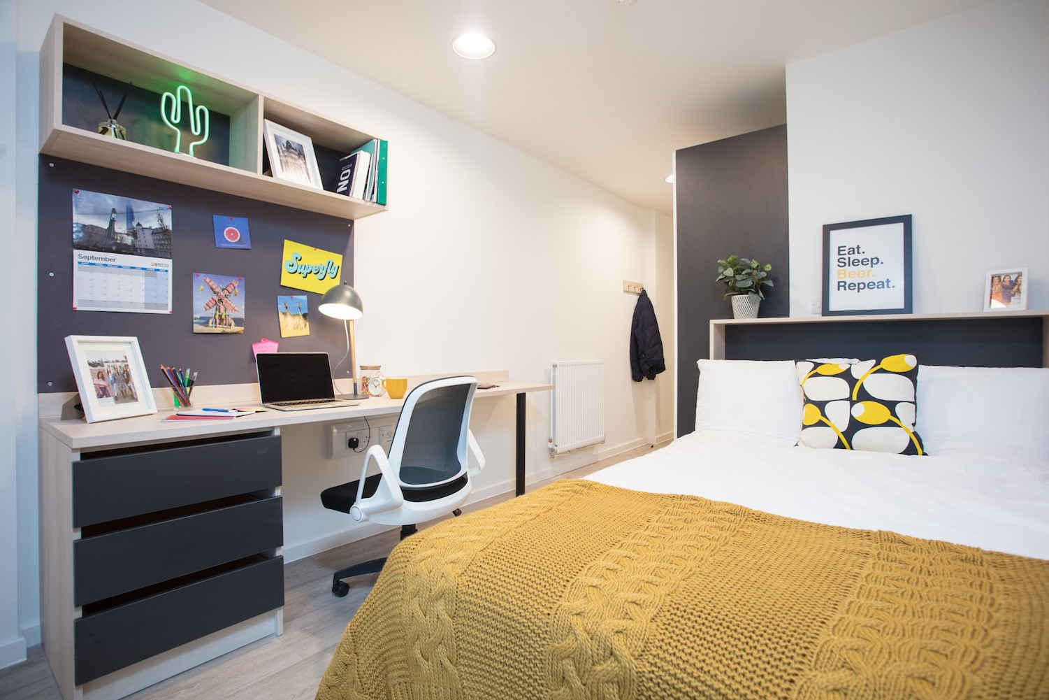 a bedroom with a bed and desk in a room